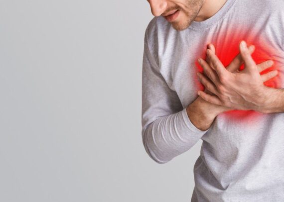 Person holding chest showing early sign of heart disease