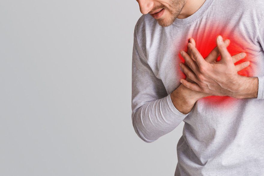 Person holding chest showing early sign of heart disease